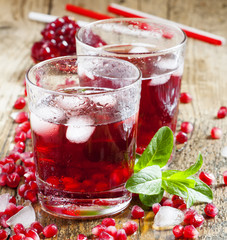 Fresh red juice cocktail with pomegranate seeds, mint and ice, s