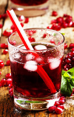 Fresh red juice cocktail with pomegranate seeds, mint and ice, s