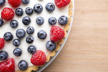 Cake with blueberries and raspberries. Confectionery product.