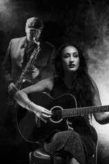 Obraz premium Lady guitarist with a saxophonist
