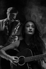 Obraz premium Lady guitarist with a saxophonist