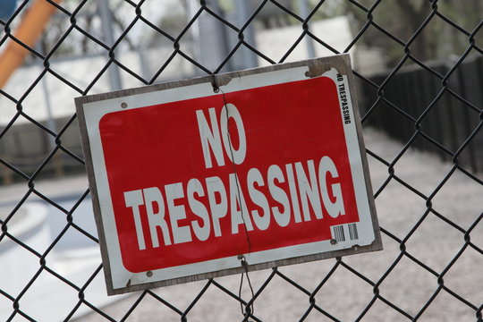 Red No Trespassing Sign On Fence