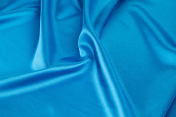 Folds of deep blue silk cloth texture.