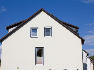 Schlichtes Wohnhaus vor blauem Himmel