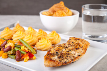 Gebratenes Hähnchenfleisch mit Herzogin Kartoffeln und Gemüse