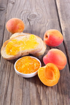 Jar of jam and ripe apricot fruits on table 