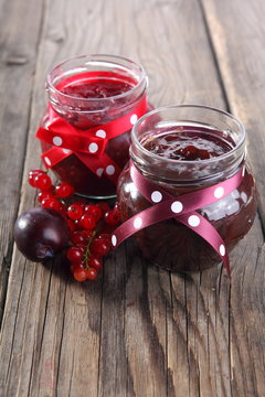 plums and jar of jam on table 