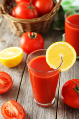 Fresh red tomatoes in basket and juice in glass 