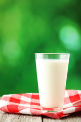 Glass of milk on grey wooden background