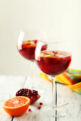 Glasses of sangria on white wooden background