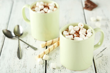 Cup of hot chocolate with marshmallows on white wooden backgroun