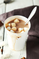 Cup of hot chocolate with marshmallows on white wooden backgroun