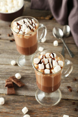 Glasses of hot chocolate with marshmallows on grey wooden backgr