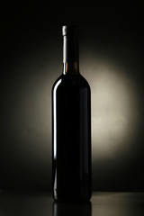 Bottle of red wine on black background