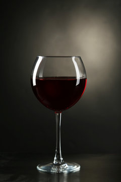 Red wine glass with bottle on black background