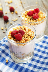 Muesli with yogurt and raspberries in a glass 