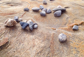Fototapeta na wymiar small rocks scattered on a large rock