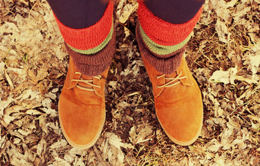 female legs in boots and colorful socks