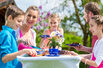 Family having coffee and cake in garden