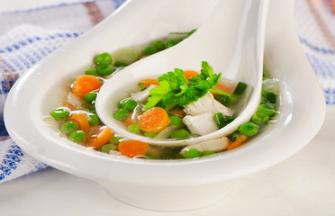 Chicken soup with vegetables in  white bowl.