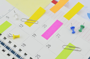 Post It notes with pin and clip on business diary page
