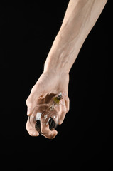 human hand holding a light bulb on black background in studio