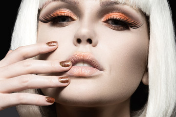 Beautiful girl in a white wig, with gold makeup and nails