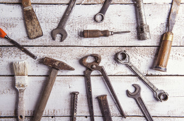 Desk of a carpenter with various tools on a wooden background.