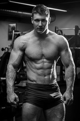 Fototapeta na wymiar Muscular man with naked torso in gym