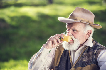 Senior farmer with organic cheese outside in nature