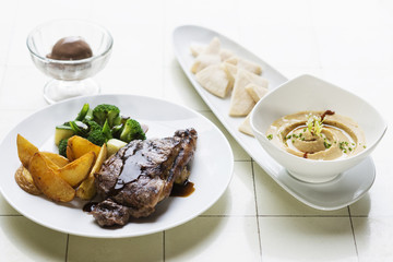 grilled steak meal with hummus dip starter