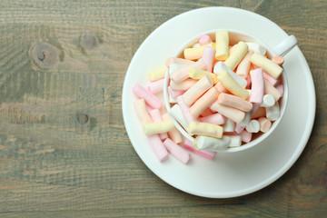 Marshmallow in a cup on a wooden background