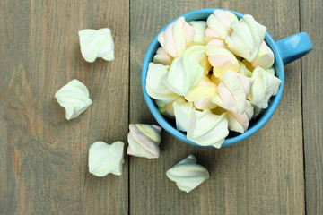 Marshmallow in a blue cup on a wooden background