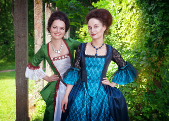 Obraz na płótnie Canvas Two young beautiful women in medieval dresses outdoor
