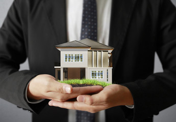 Businessman holding house model
