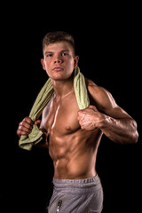 Fototapeta premium muscular young bodybuilder man with towel on neck