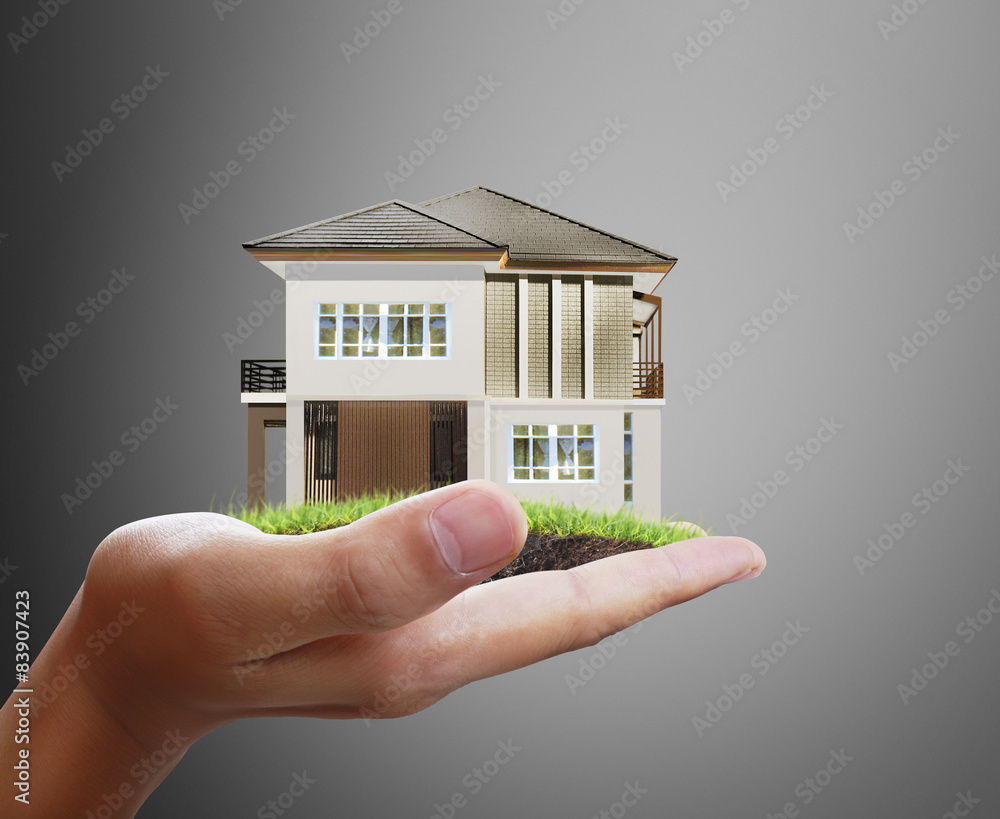 Wall mural Businessman holding house model