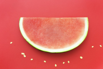 Slice of watermelon without seeds on red background