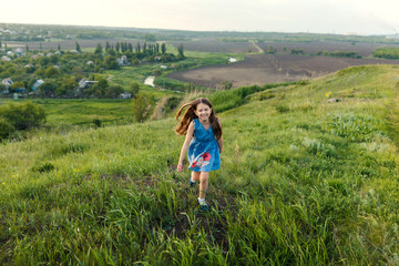 Naklejka na ściany i meble Little girl running on meadow