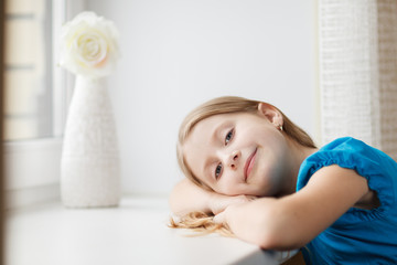 Obraz na płótnie Canvas Little girl lie on windowsill