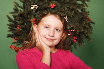 Little girl with spruce wreath