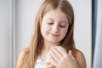 Little girl on windowsill with toy