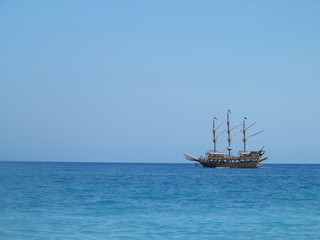 Fototapeta na wymiar Old wooden old ship in blue sea