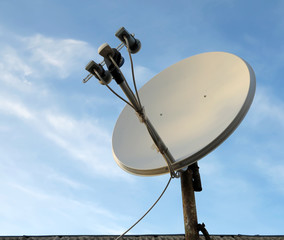 Satellite dish antenna over blue sky background