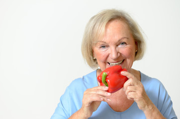 Seniorin riecht an einer Paprika