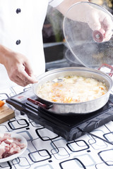 Chef putting stir fried Japanese pork curry to the pot / cooking