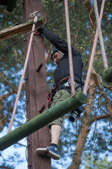young man  climbing in adventure park, rope park 