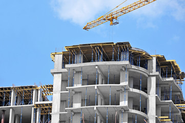 Crane and building construction site against blue sky