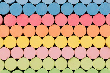 cylindric colored chalks stacked on black background