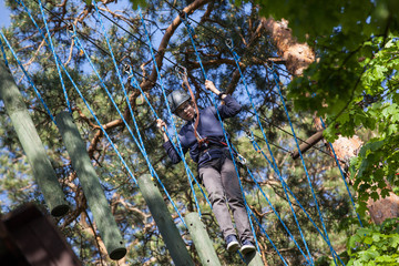 boy climbing in adventure park, rope park  